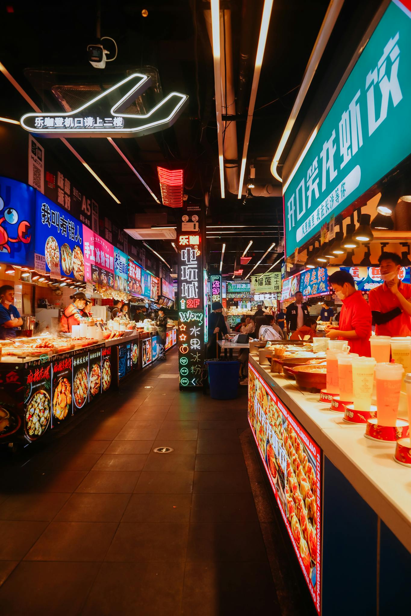 Explore the lively atmosphere of a neon-lit street food market with bustling vendors and glowing signage.